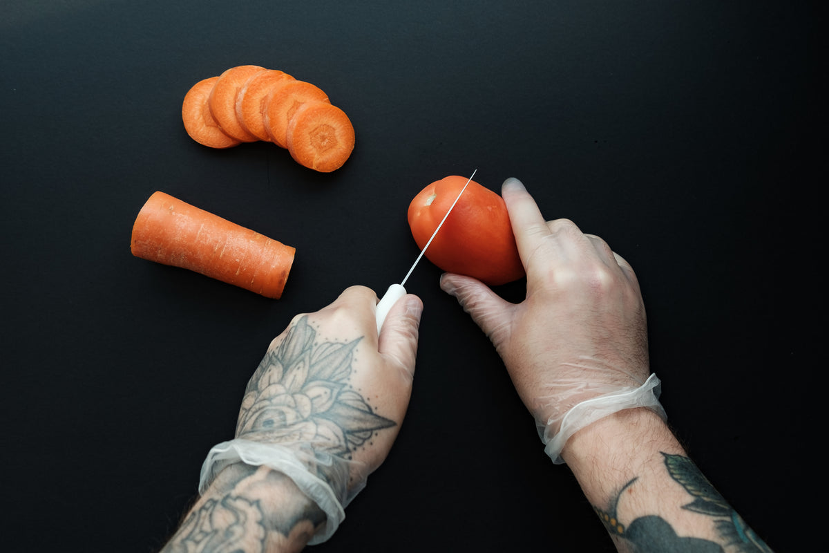 Preparación de alimentos con guantes en una cocina central de producción